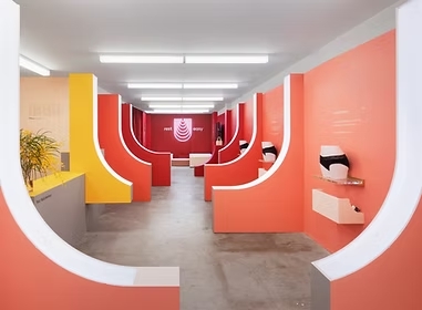 Bold coral coloured retail pop-up space with curved forms